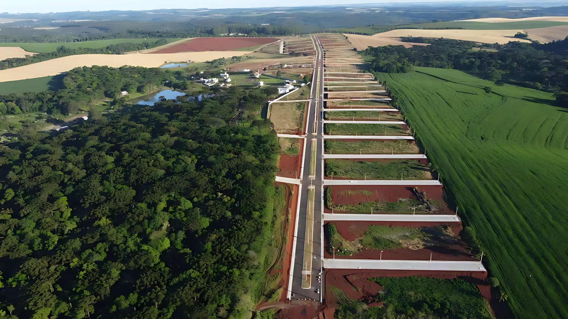 Vista aérea do Ville Bodanese: avenida principal, quadras e mata nativa